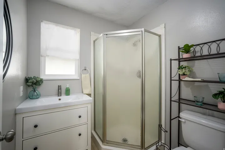 Corner vanity with integrated sink, a single-handle faucet, and two storage drawers