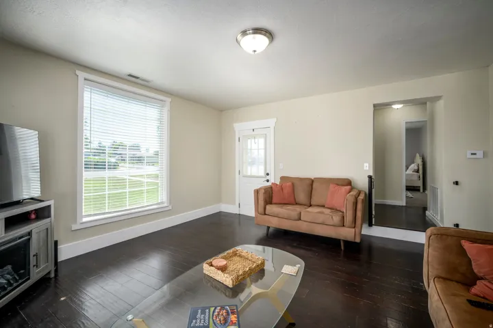 Hardwood-finish flooring, recessed lighting, and a large window with horizontal blinds