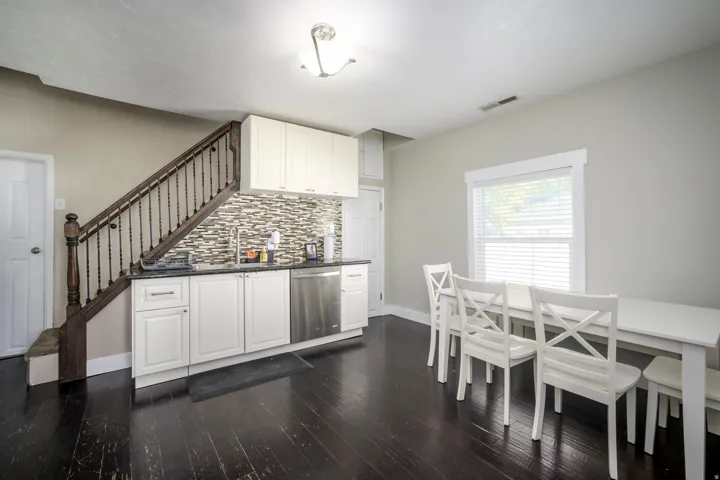 Kitchenette featuring white cabinetry, a mosaic tile backsplash, and stainless steel appliances