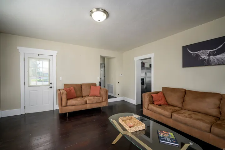 Dark wood-finish flooring, light-toned wall paint, recessed ceiling light fixture, white trim, and a paneled door with glass inserts