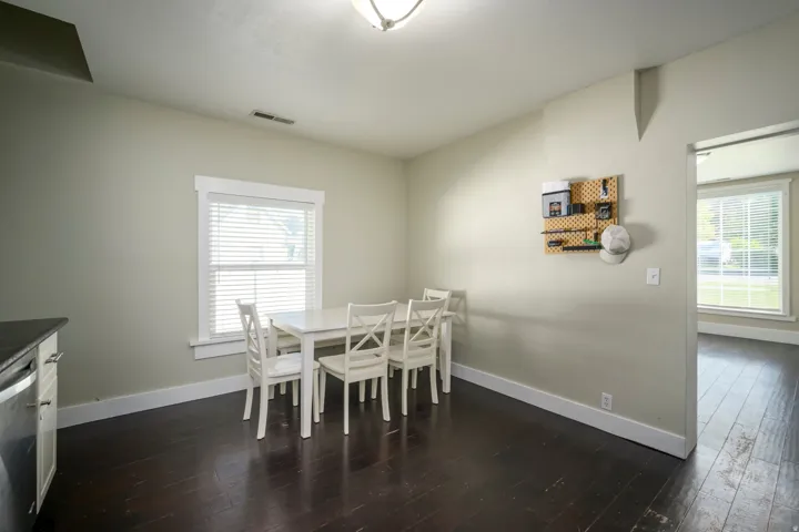 Dark wood-finish flooring, light-toned walls, and a window with blinds