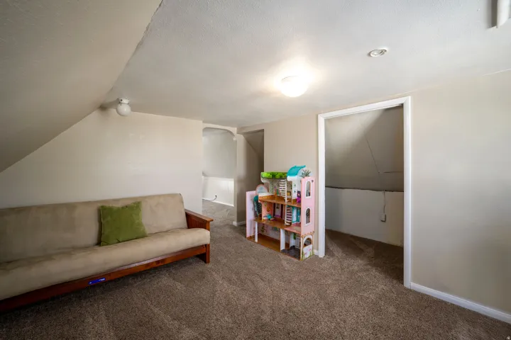 Carpeted room with sloped ceilings, recessed lighting, and an overhead light fixture