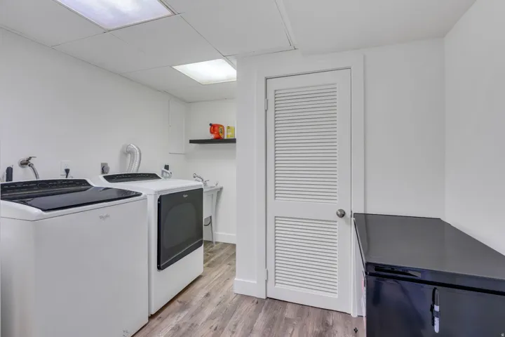 Utility space featuring wood-finish flooring and a louvered interior door
