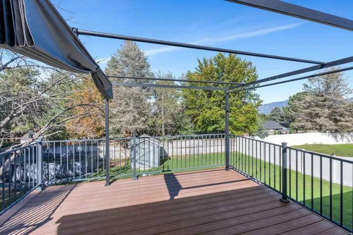 Expansive outdoor deck featuring wood-finish flooring and black metal railings