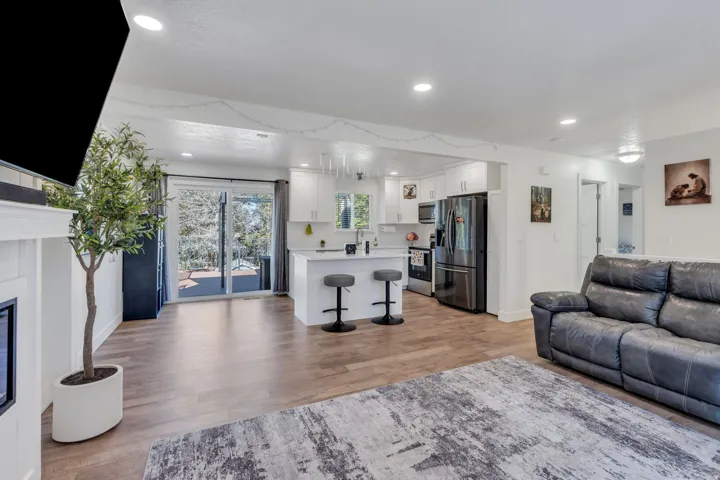 Open-concept living space featuring hardwood flooring throughout, recessed lighting, and stainless steel appliances