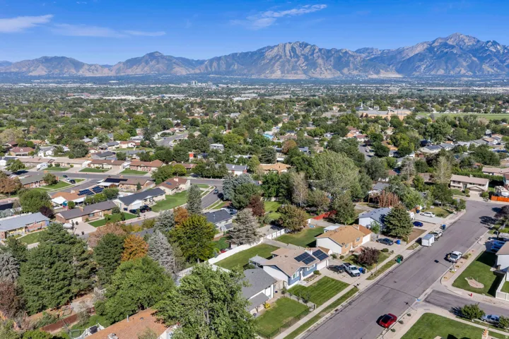 Expansive suburban setting with mature trees and mountain backdrop