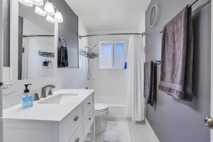 Vanity with an integrated sink, brushed nickel faucet, and a wall-mounted mirror