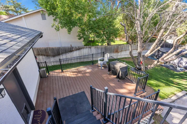 Multi-level deck with composite decking, black metal railings, and a shingle roofline with gutters