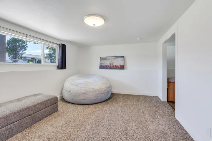 Plush carpeting, recessed window, flush-mount ceiling light, white painted walls, and a visible doorway