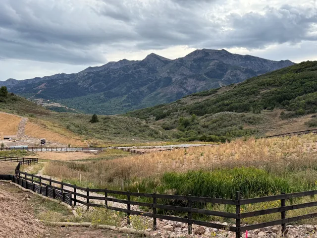 Expansive landscape featuring distant mountains, rolling hills, and natural vegetation