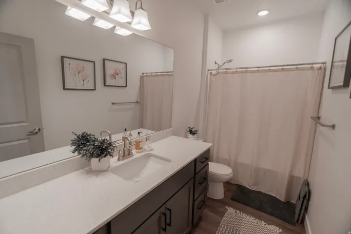Vanity with a light-toned countertop, undermount sink, and dark cabinetry