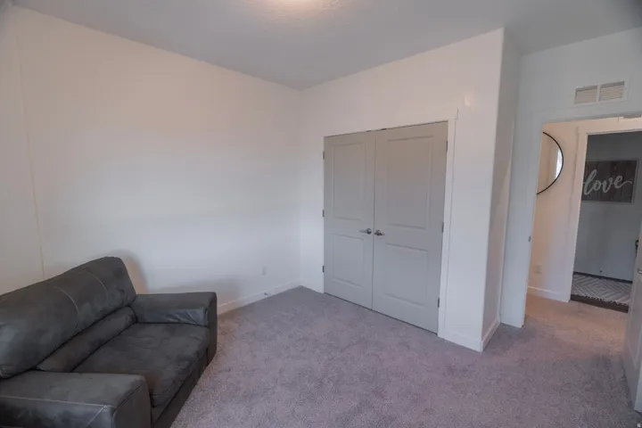 Neutral wall finishes, recessed lighting, gray wood-finish doors, and gray carpeting