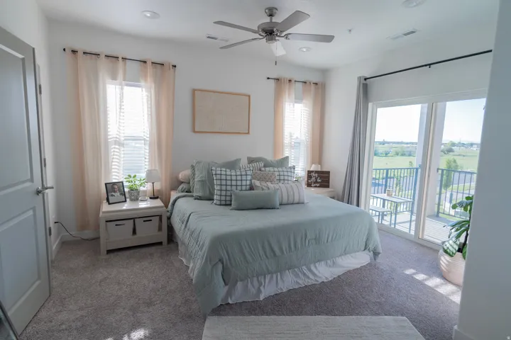 Plush carpet flooring, recessed ceiling lighting, a ceiling fan, and a built-in sliding glass door leading to an outdoor balcony