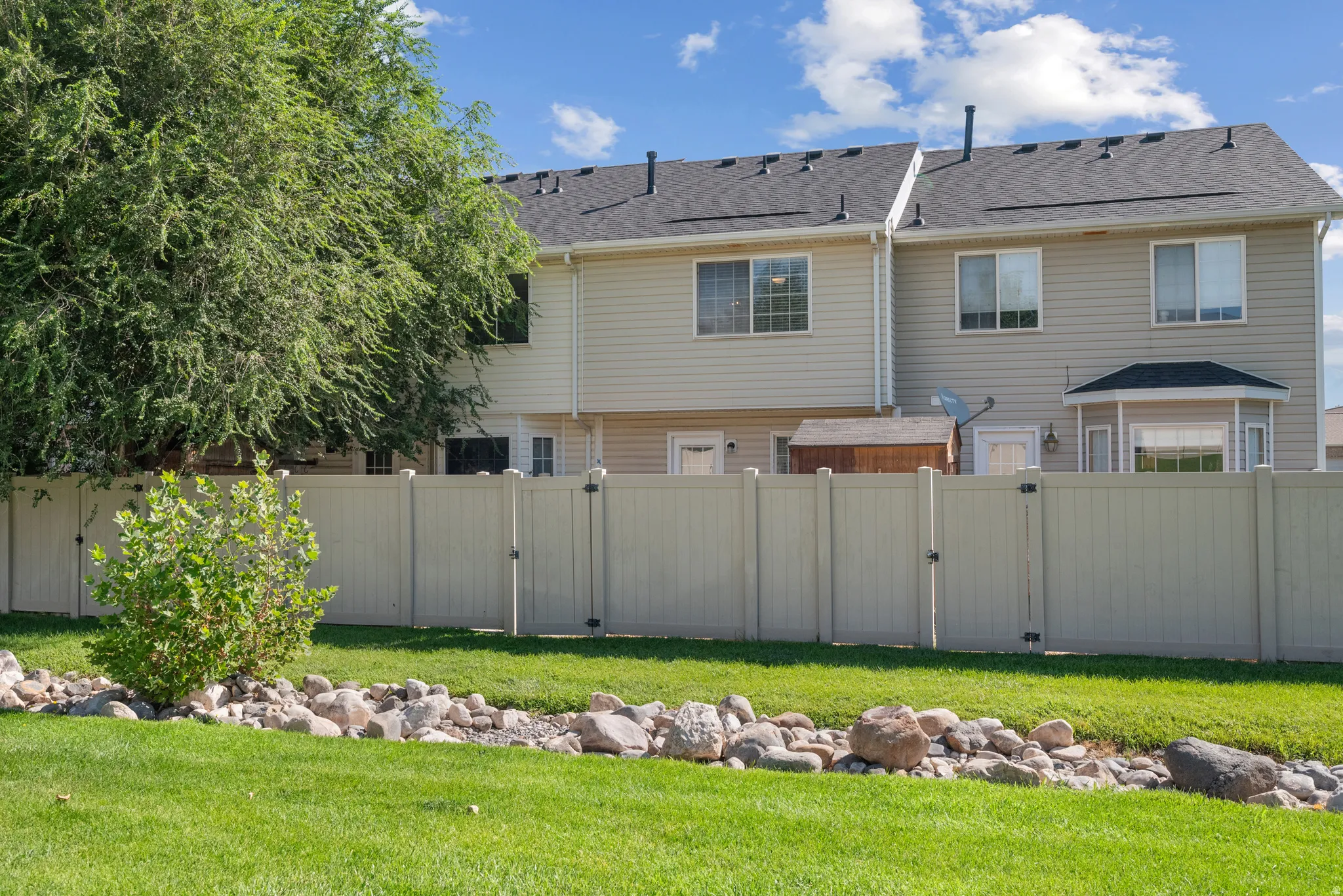 Exterior featuring bay window, horizontal siding, and a private fence