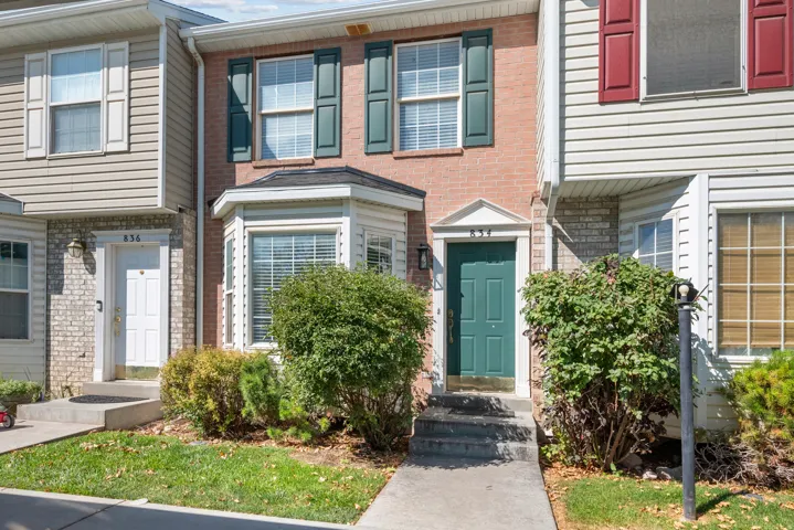 Brick and siding exterior with a front entry door, bay window, and exterior lighting