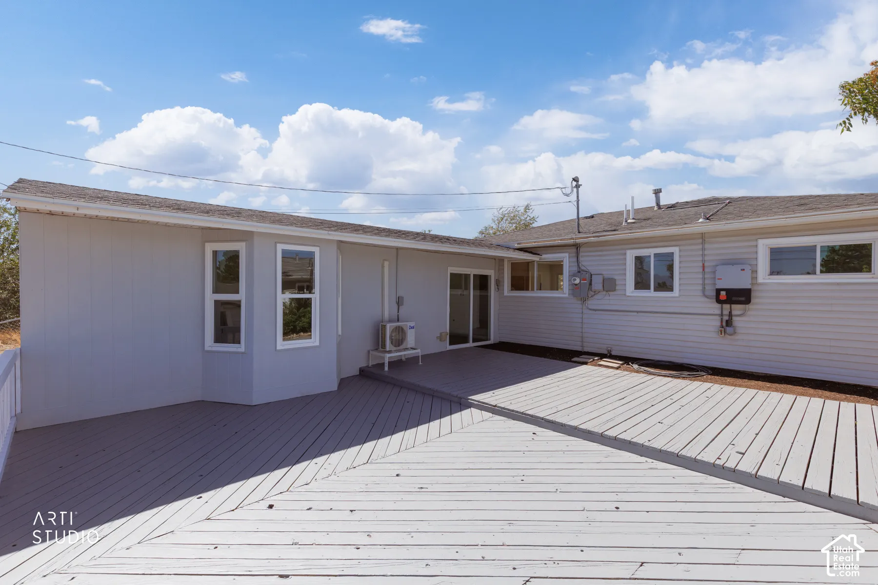Expansive outdoor decking, sliding glass door access, bay window detail, and durable siding