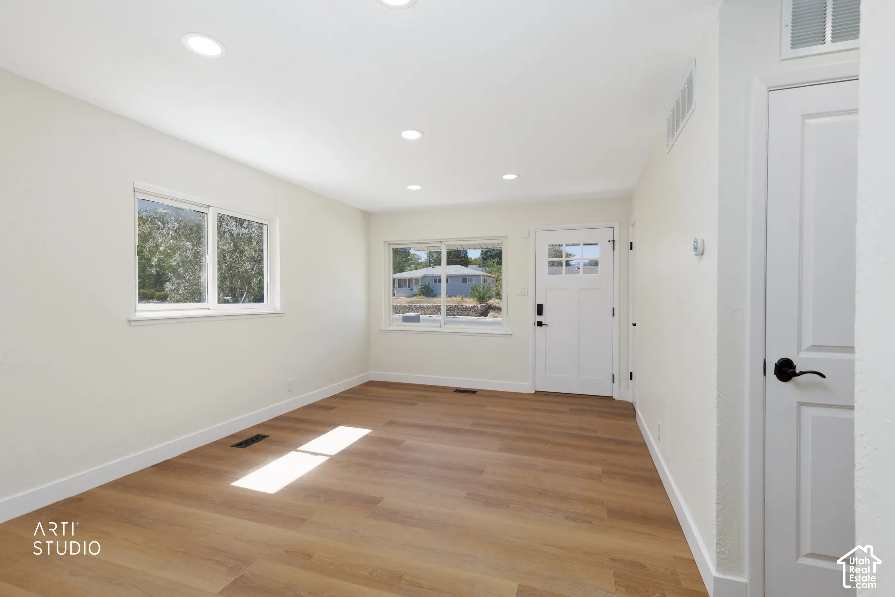 Recessed lighting, wood-finish flooring, multiple windows, white interior doors, and white baseboards