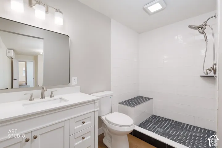 White vanity with an integrated sink and brushed nickel faucet, large wall mirror, walk-in shower with a built-in bench, and a dual-head shower system