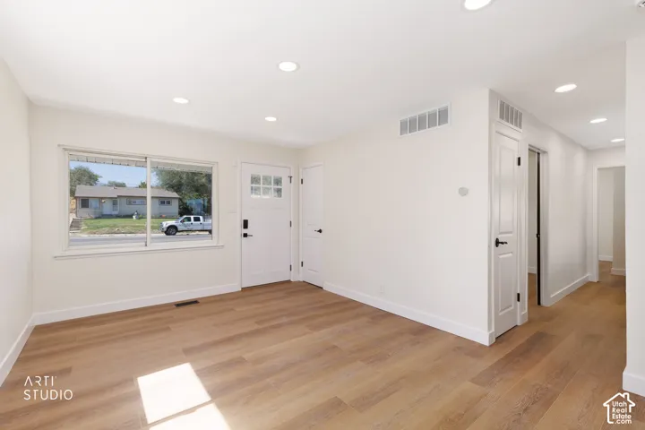 Recessed ceiling lighting, wood-finish flooring, white trim, paneled interior doors, and a front entry door with glass inserts