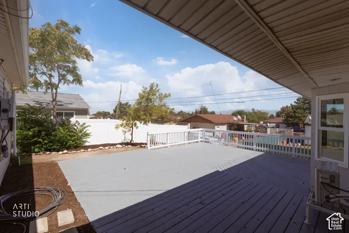 Expansive outdoor deck with a protective overhead covering and white railing