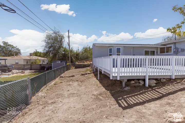 Expansive deck with white railings and gray decking, featuring direct access to the home