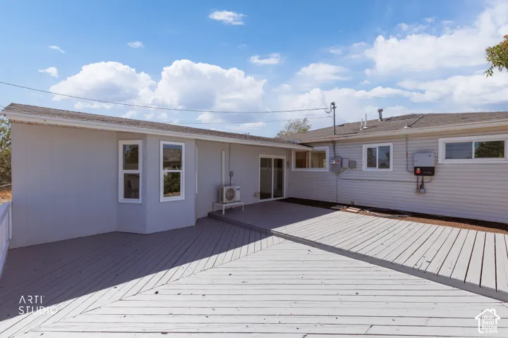Expansive outdoor decking, sliding glass door access, bay window detail, and durable siding
