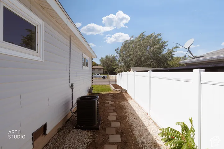 White vinyl siding with trim, individual windows, and an outdoor HVAC unit