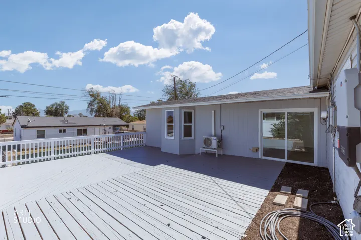 Expansive outdoor deck with a white railing system, light gray wood-finish decking, and a sliding glass door