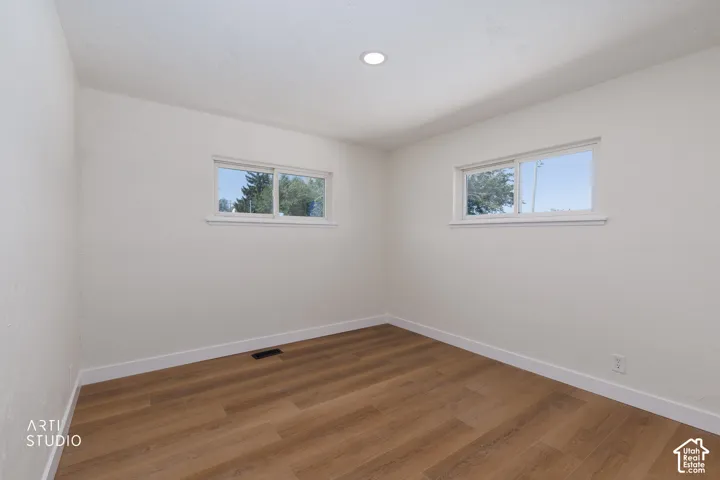 Wood-finish flooring, recessed ceiling light, and two windows