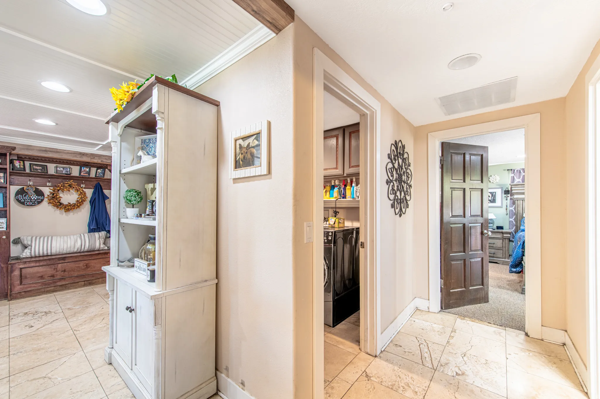 Recessed lighting, wood beam ceiling detail, built-in shelving, wood-finish paneled door, and tile flooring