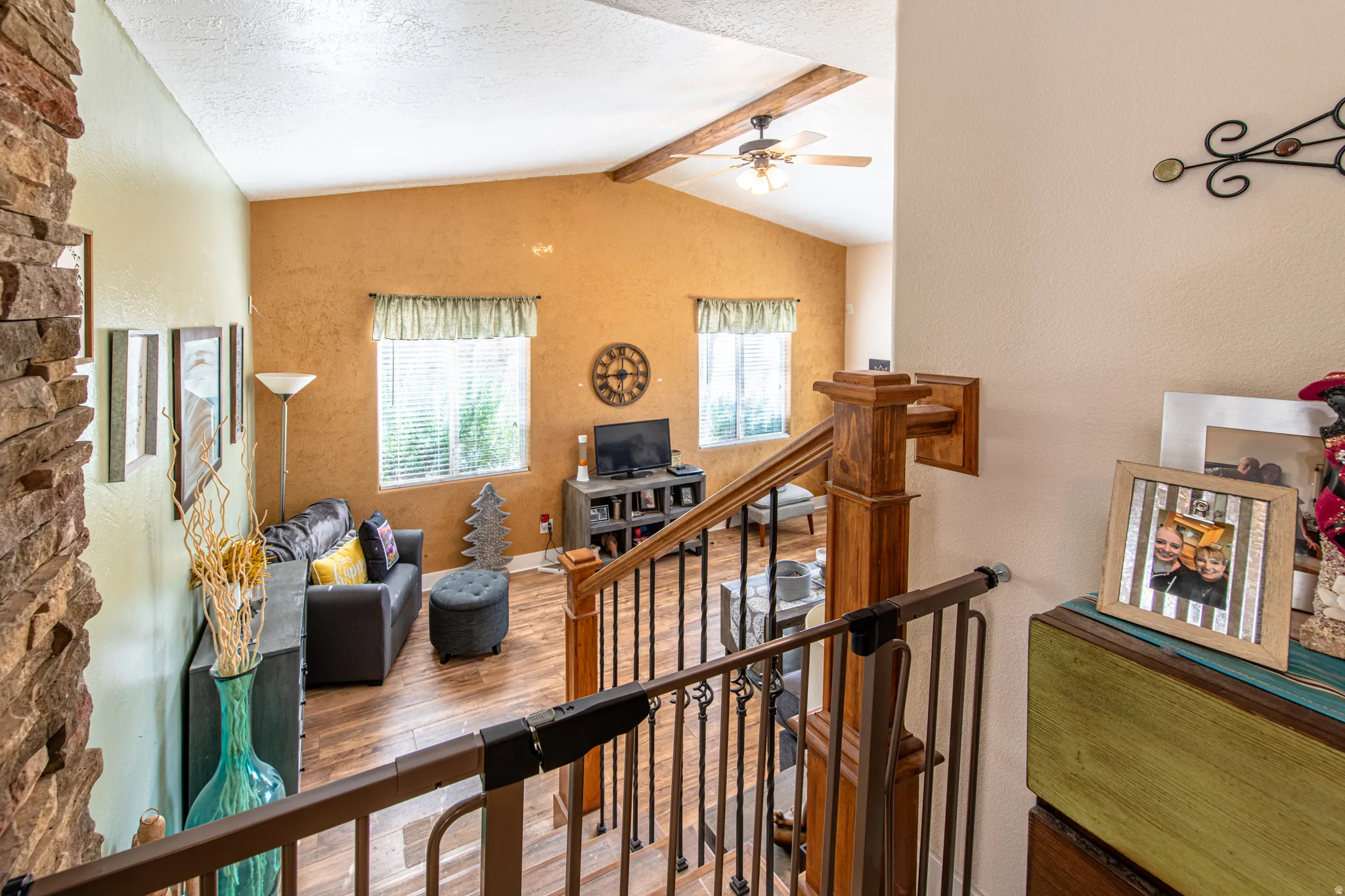 Vaulted ceiling with exposed wood beams and ceiling fan