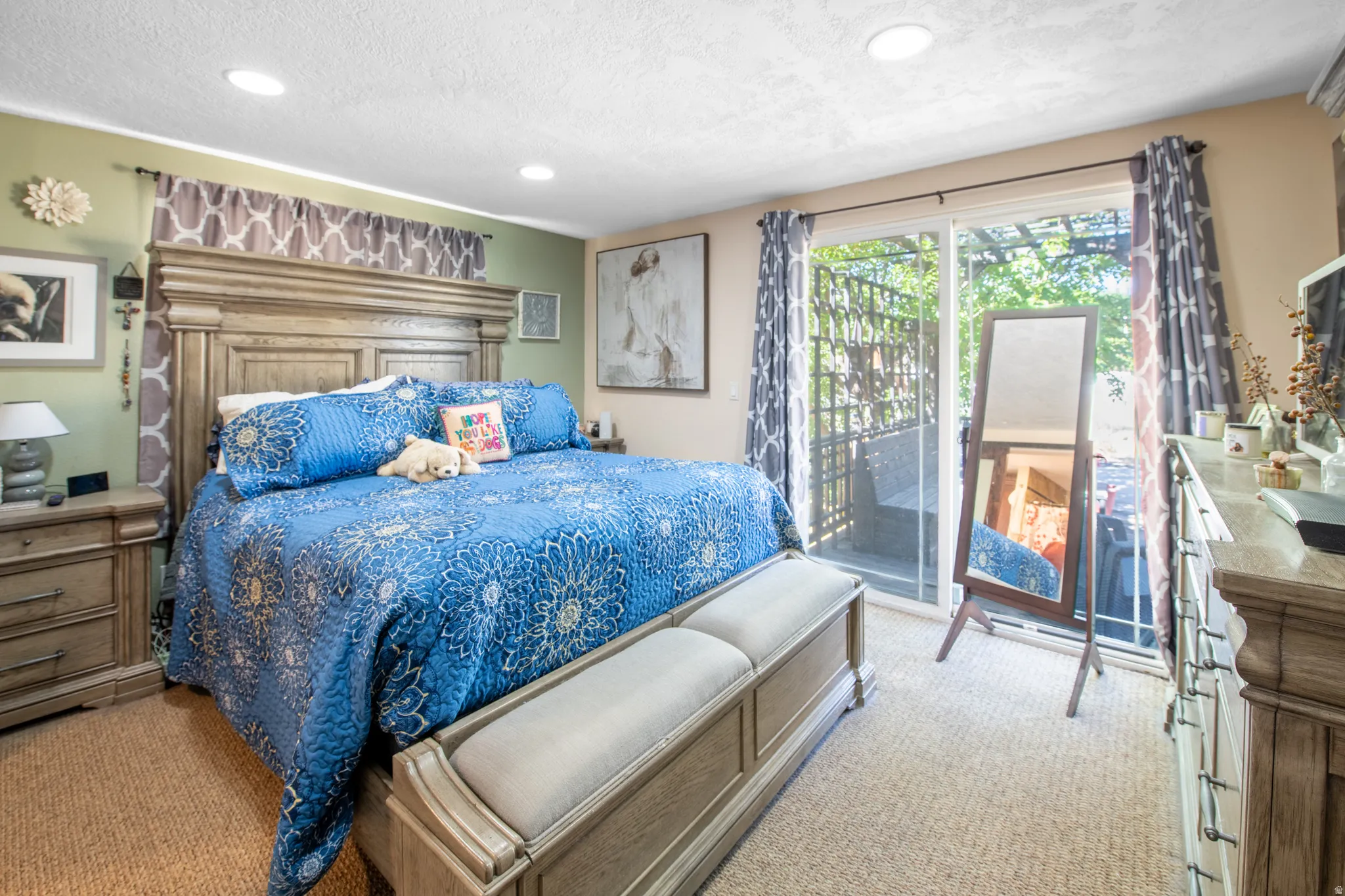 Recessed lighting, sliding glass door, textured carpet, and neutral wall color