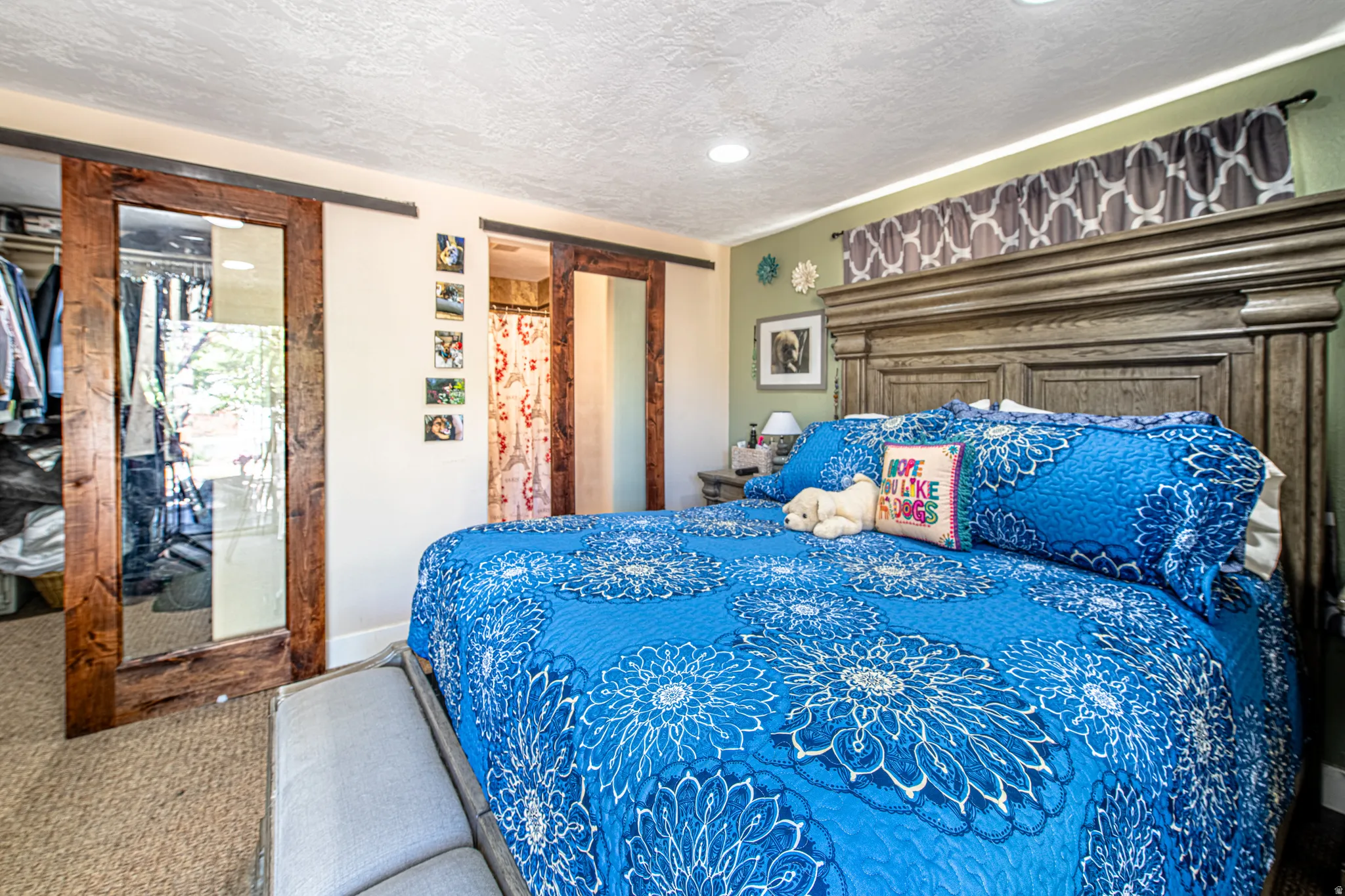 Wood-finish sliding barn doors, recessed ceiling lighting, and textured ceiling finish