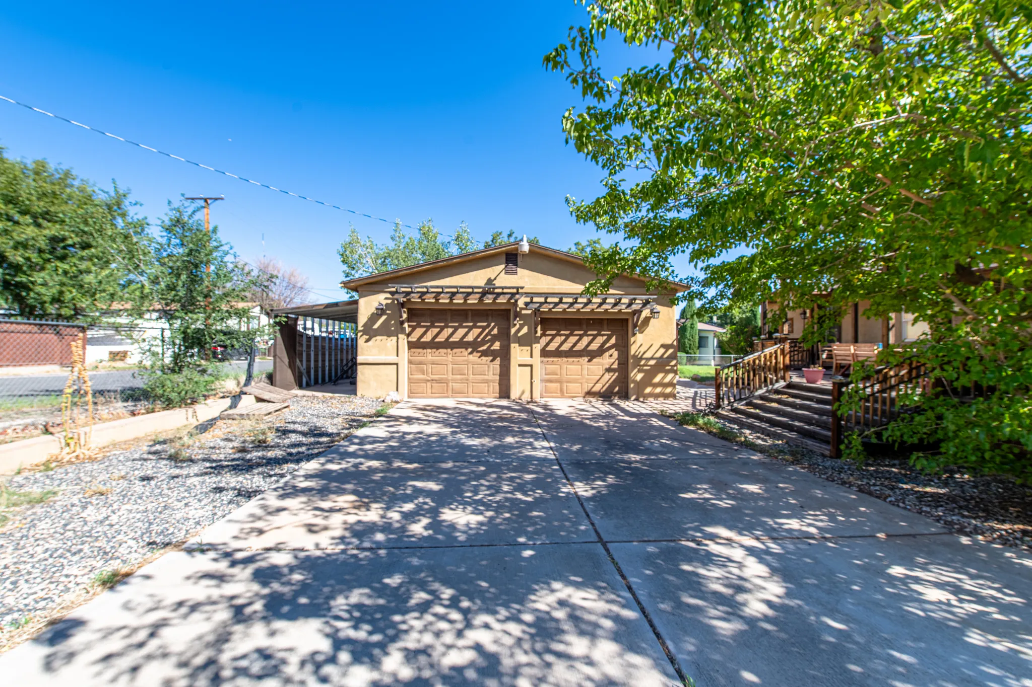 Two-car garage with wood-finish doors and an attached pergola