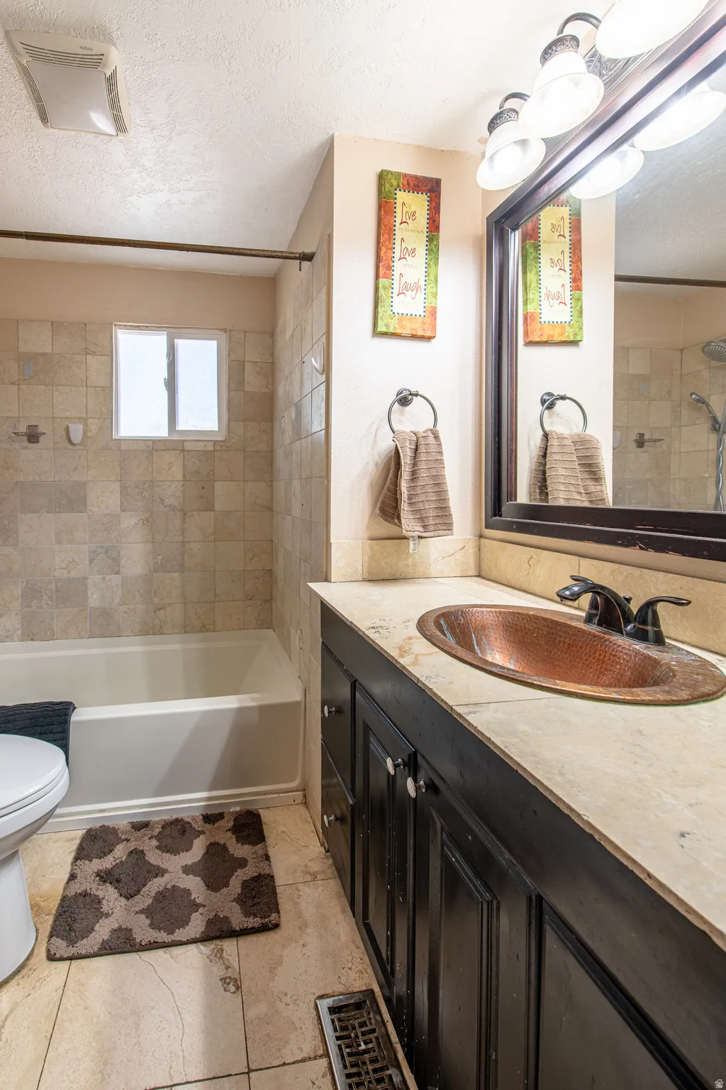 Built-in vanity with a copper basin sink, dark wood cabinetry, and a light-toned countertop