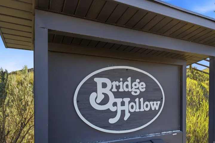 Prominent property signage with a dark wood-finish background and white lettering
