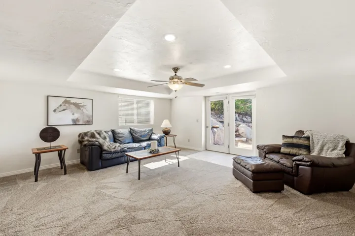 Recessed lighting, tray ceiling, ceiling fan, carpet flooring, and French doors
