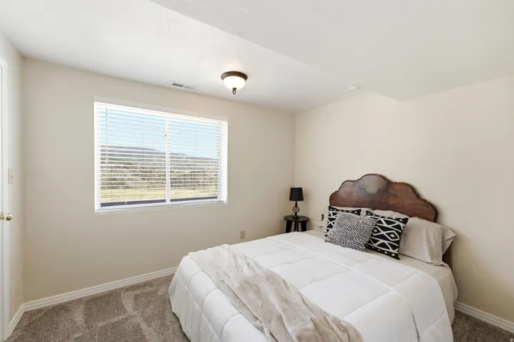 Wall-to-wall carpeting, window with blinds, ceiling-mounted light fixture, and light-toned walls
