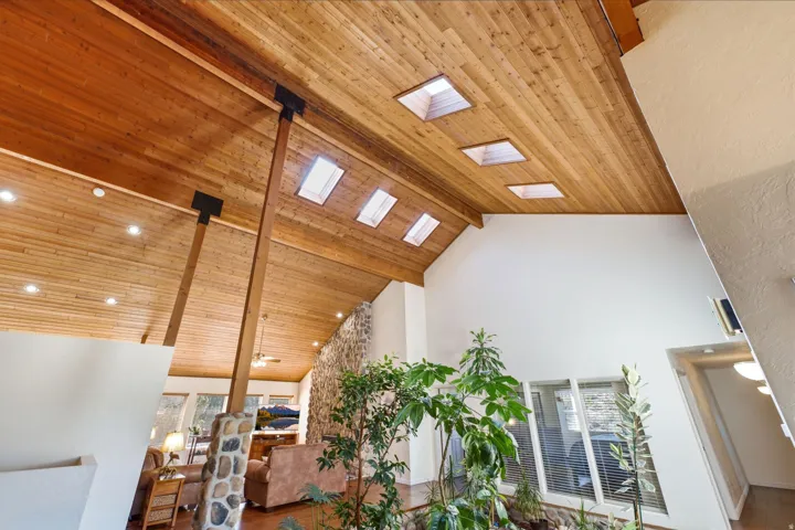 Vaulted wood-finish ceiling with skylights and recessed lighting