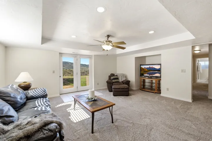 Recessed lighting, ceiling fan, carpet flooring, built-in media niche, and double glass doors