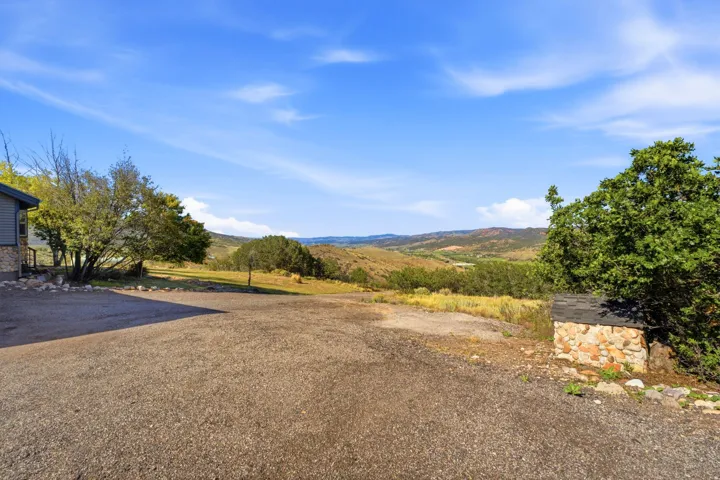 Spacious gravel lot with a stone and siding exterior