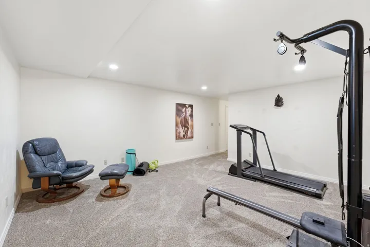 Carpeted room with recessed lighting and light-toned walls