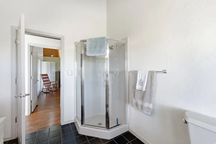 Corner glass-enclosed shower with a shower head