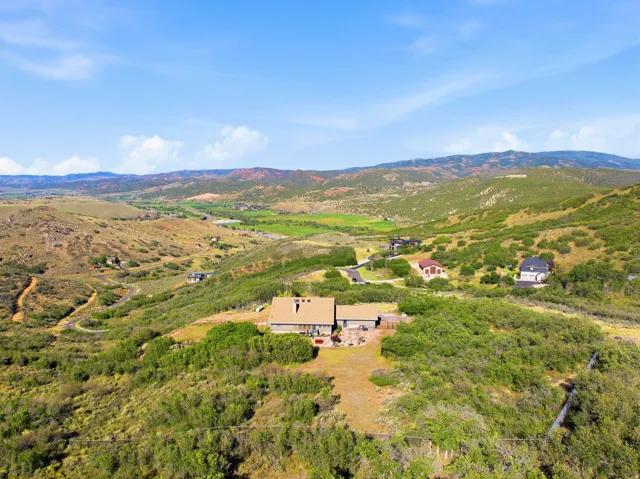 Property situated on a sloped, natural landscape with mature trees