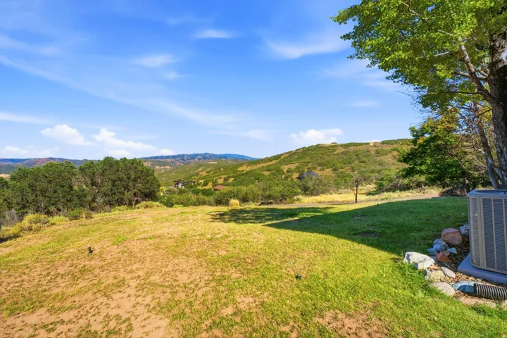 Expansive outdoor area featuring varied natural landscaping and distant hills