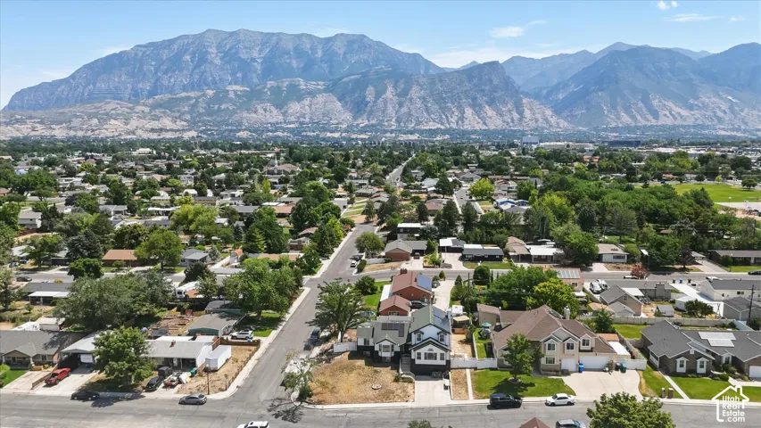 Mountain backdrop, neighborhood setting, mature trees, residential properties, paved streets