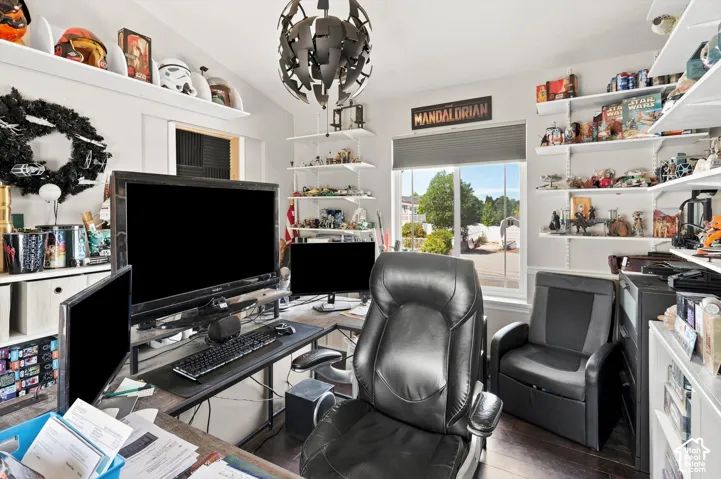 Room featuring dark wood-finish flooring, white walls, built-in shelving, and a large window