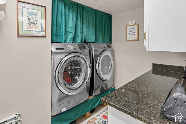 Built-in stacked laundry area with front-loading appliances, complemented by a dark speckled countertop and white upper cabinetry