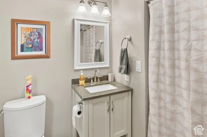 White vanity with a stone-finish countertop and undermount sink