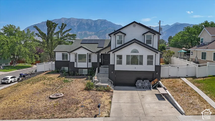 Two-story residence with a two-car garage, solar panels, and a mountain backdrop